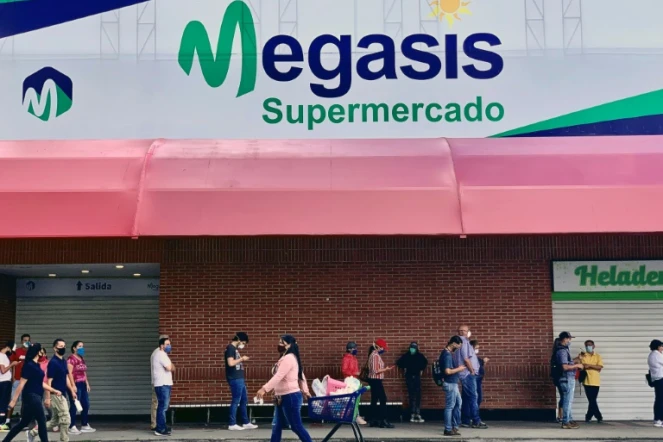 Des clients font la queue devant le supermarché Megasis à Caracas le 31 juillet 2020