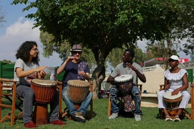 Le Gambien Ibrahim Kamara (2e d), demandeur d'asile, joue du djembé avec ses élèves lors d'une foire de la diversité à Nicosie, le 14 mai 2023 à Chypre