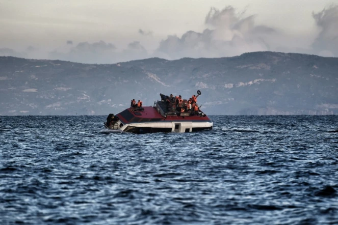 Des migrants et réfugiés appellent à l'aide alors que leur bateau est en train de couler près des côtes de l'île grecque de Lesbos, le 30 octobre 2015 en mer Egée