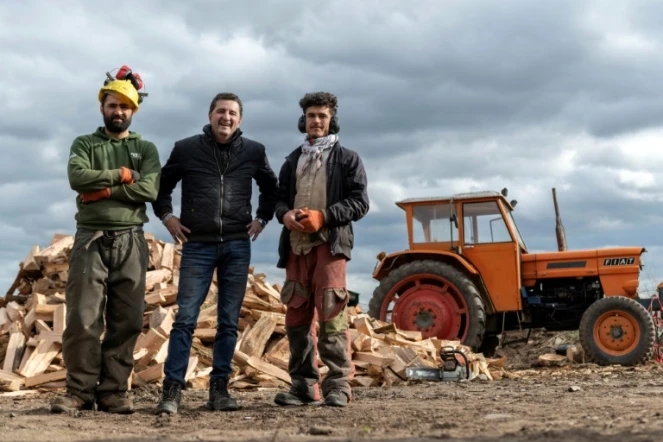 Les Afghans Matiullah Mehrabi (g) et Sherbaz Safizada (d) avec leur employeur Alain Capella, patron d'une scierie familiale, le 24 février 2022 à Aigueperse, dans le Puy-de-Dôme