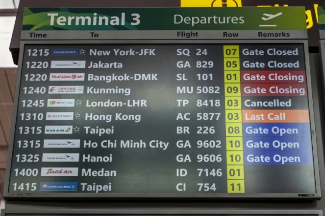 Un tableau d'information indique que le vol TP8418 d'Air Portugal à destination de Londres Heathrow est annulé à l'aéroport Changi de Singapour, le 21 mars 2025