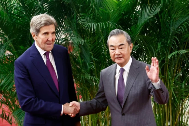 L'émissaire américain pour le climat John Kerry (g) et le chef de la diplomatie chinoise Wang Yi se serrent la main avant une réunion à Pékin, le 18 juillet 2023