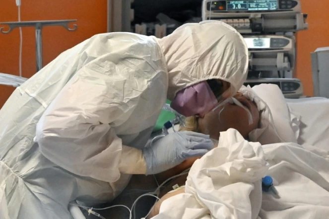 Un membre du  personnel soignant autour d'un patient atteint du nouveau coronavirus au service des soins intensifs de l'hôpital Casalpalocco près de Rome, le 24 mars 2020