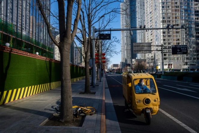 Un livreur conduit son véhicule électrique dans une rue désertée de Pékin le 3 mars 2020