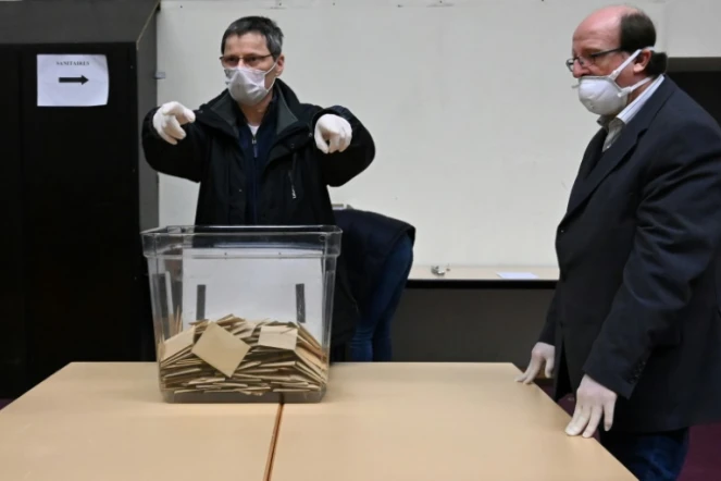Des personnels portant des masques de protection et des gants dans un bureau de vote à Strasbourg, le 15 mars 2020