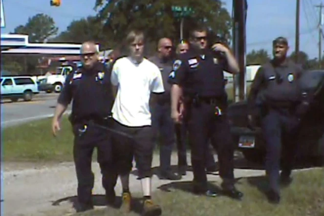 Dylann Roof, en blanc, au milieu de policiers de Shelby en Caroline du Nord après son arrestation, le 18 juin 2015