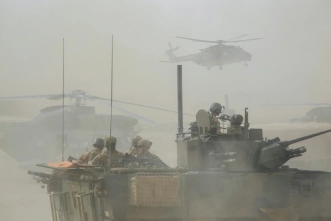 Un blindé et des hélicoptères militaires français de l'opération Barkhane le 27 mars 2019 dans la région malienne de Gourma