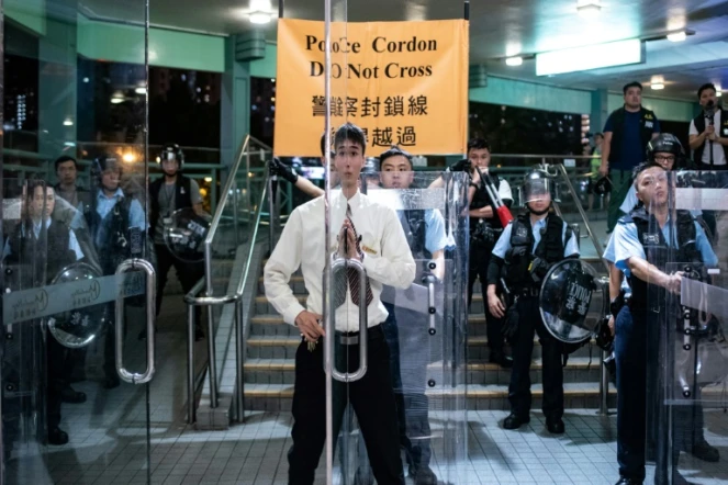 Un agent de sécurité ferme les portes d'une galerie commerciale lors d'une manifestation à Hong Kong, le 13 juillet 2019