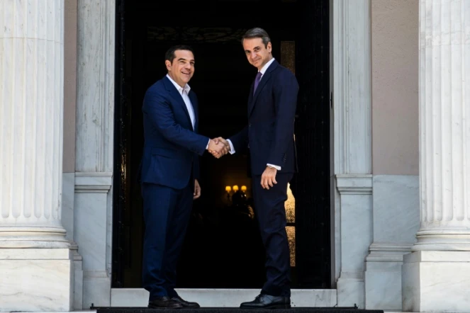 Le nouveau Premier ministre grec Kyriakos Mitsotakis (g) et son prédécesseur, Alexis Tsipras, se serrent la main après leur rencontre à la villa Maximos,  le 8 juillet 2019 à Athènes