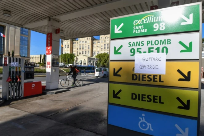 Un cycliste passe à côté d'une station essence à Montpellier le 4 décembre 2018