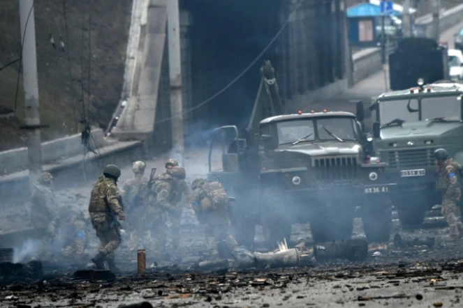 Des soldats ukrainiens récupèrent un obus non explosé à Kiev, le 26 février 2022
