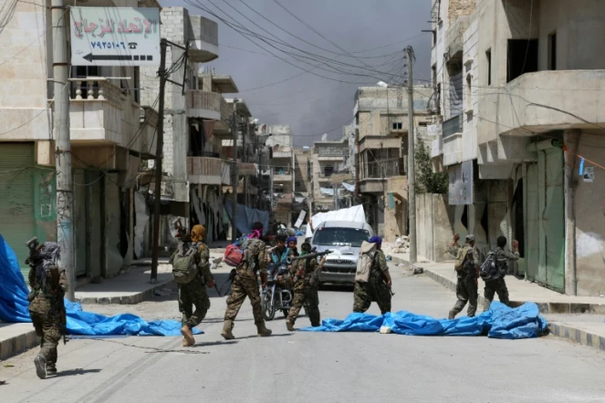Des membres de forces démocratiques syriennes dans une rue de Minbej en Syrie, le 7 août 2016