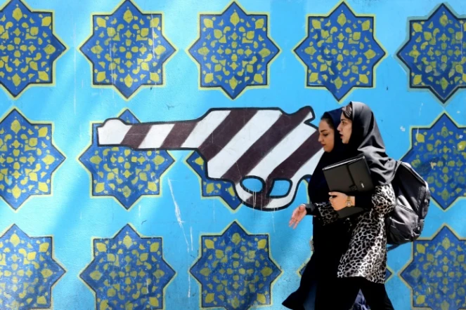 Des Iraniennes passent devant une peinture sur le mur de l'ancienne ambassade américaine à Téhéran, le 22 juin 2019