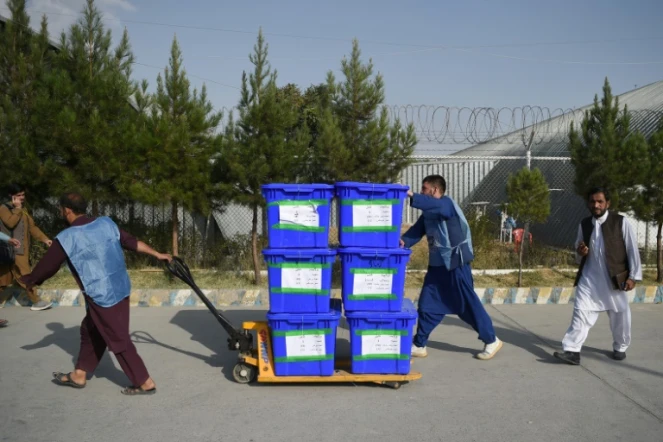 Des membres de la commission électorale indépendante transportent des bulletins de vote pour qu'ils soient comptabilisés, le 2 octobre 2019 à Kaboul en Afghanistan