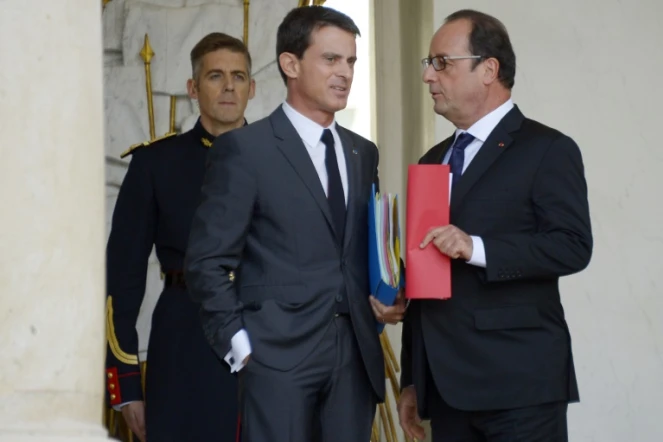 Le président français François Hollande (d) et son Premier ministre Manuel Valls (c) sur le perron de l'Elysée à Paris, le 23 septembre 2015