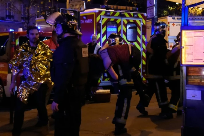 Un pompier transporte une victime des attaques survenues dans le centre de Paris, le 13 novembre 2015