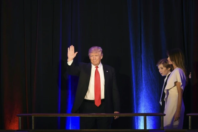 Le président élu Donald Trump, accompagné de son fils Baron et de sa femme Melania, salue ses supporteurs, le 9 novembre 2016 à New York