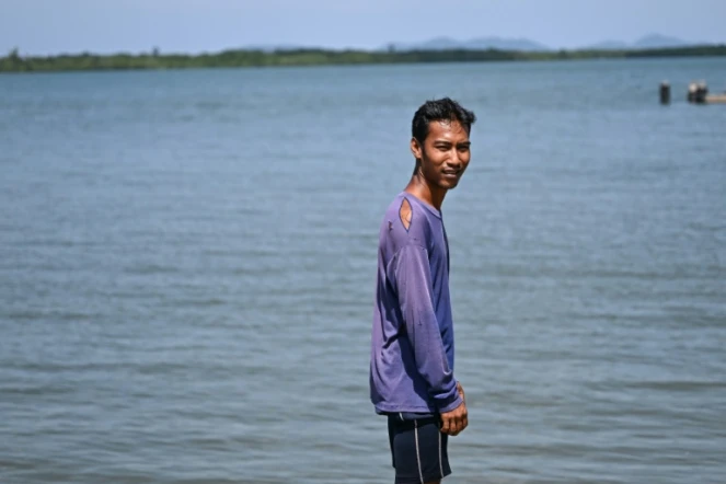 Pirun Kla-Talay, qui a perdu ses parents dans le tsunami de 2004, debout sur une jetée dans le district de Bang Wa, dans la province de Phang Nga, le 19 novembre 2024 en Thaïlande