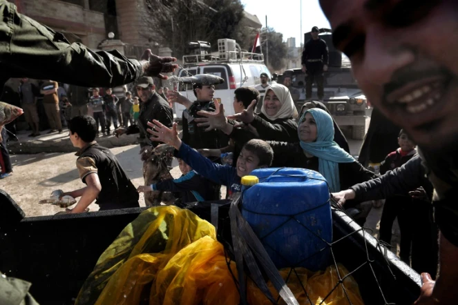 Les troupes irakiennes distribuent de la nourriture à des civils le 10 mars 2017 à Mossoul