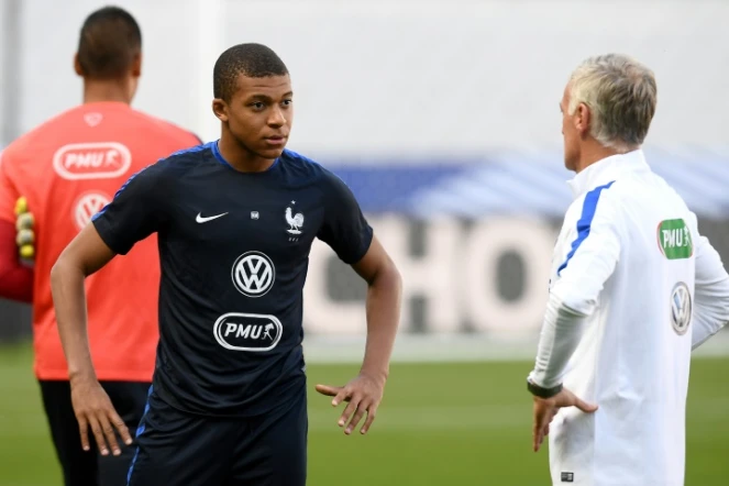 L'attaquant de l'équipe de France Kylian Mbappe (g) parle au sélectionneur Didier Deschamps lors d'une séance d'entraînement au stade de France, le 12 juin 2017 