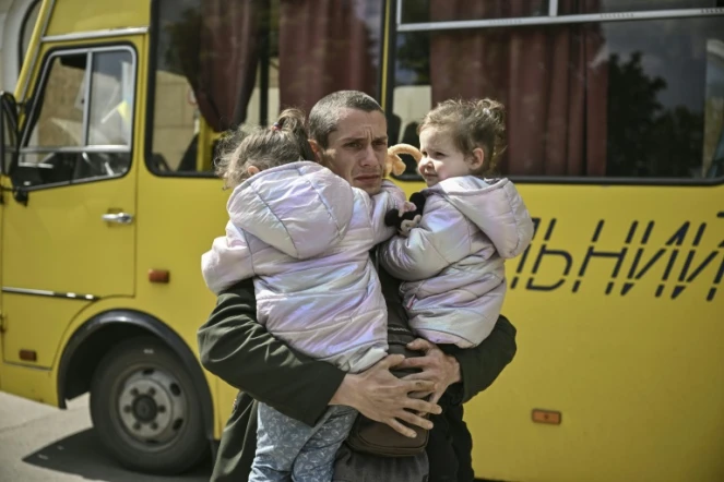 Dmytro Mosur, 32 ans, qui a perdu sa femme dans un bombardement près de Severodonetsk porte ses jumelles de deux ans, en attendant d'être évacués de Lyssytchank, le 20 mai 2022