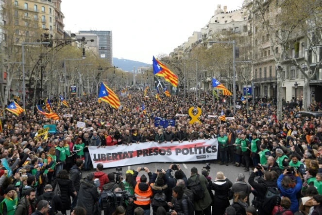 Manifestants devant les bureaux de la Commission européenne à Barcelone le 25 mars 2018 pour protester contre l'arrestation de Carles Puigdemont en Allemagne, à la demande de la justice espagnole. Il est écrit "Liberté pour prisonniers politiques" sur la banderole.