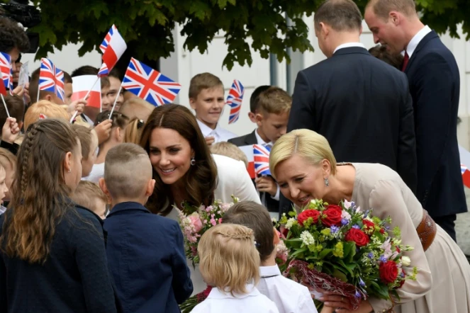 La duchesse de Cambridge Kate Middleton (G) et la femme du président polonais, Agata Kornhauser-Duda (D), reçoivent des fleurs lors d'une cérémonie au palais présidentiel à Varsovie, le 17 juillet 2017