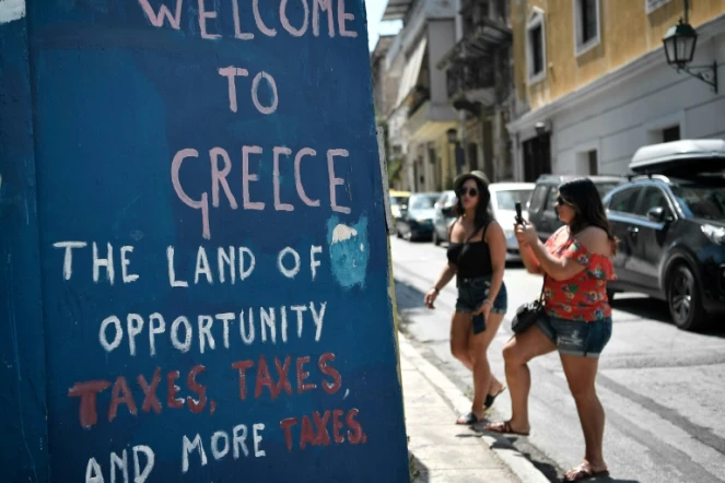 "Bienvenue en Grèce, pays d'opportunités, taxes, taxes et encore des taxes", lit-on sur un mur au centre d'Athènes, le 18 août 2018