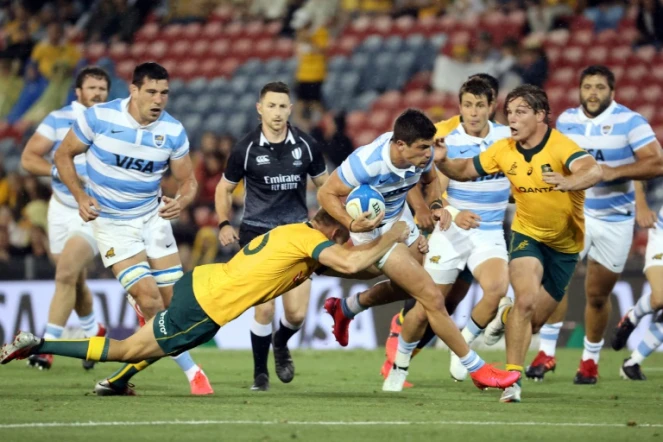 Les Australiens Reece Hodge (g) et Michael Cooper tentent de stopper l'Argentin Bautista Delguy, lors de leur match comptant pour la 4e journée du Rugby Championship, le 21 novembre 2020 à Newcastle en Australie (Nouvelle-Galles du sud)
