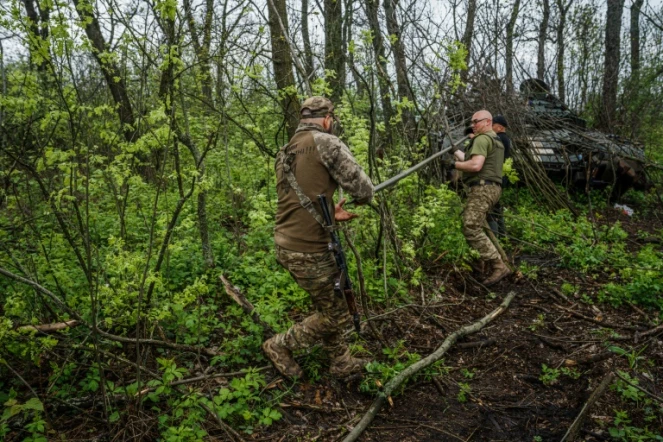 Des soldats ukrainiens nettoient le canon de leur char sur la ligne front près de la ville de Bakhmout, en Ukraine, le 30 avril 2023