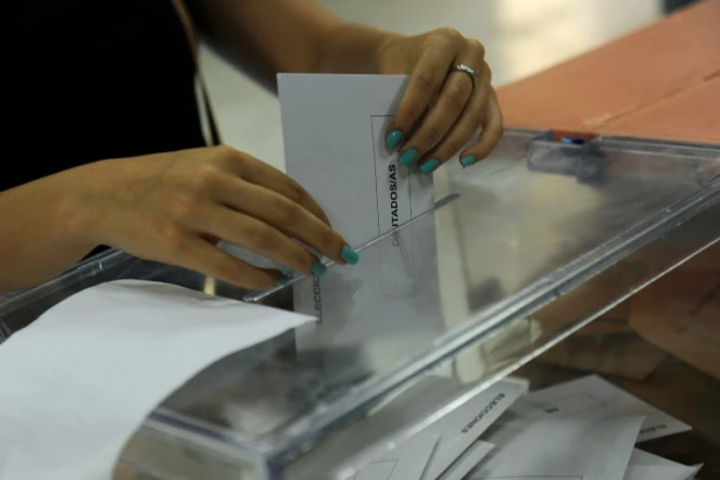 Une femme met son bulletin dans l'urne lors des élections législatives en Espagne, le 26 juin 2016 