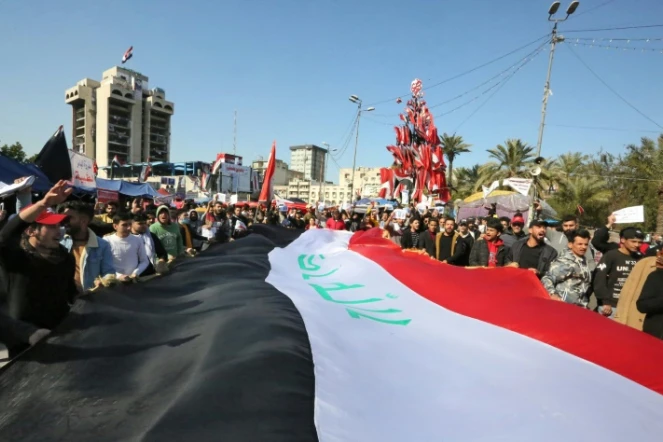 Des manifestants antigouvernementaux agitent un drapeau irakien géant sur la place Tahrir, dans le centre de la capitale Bagdad, le 2 février 2020