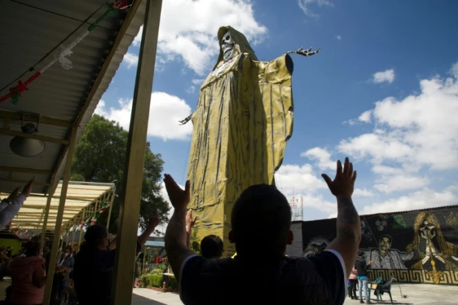 Des Mexicains prient devant la Santa Muerte, une statue représentant la mort, le 4 octobre 2020 à Tultitlan