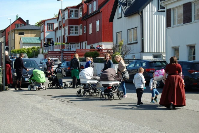 Des habitants, certains en costume traditionnel, avec poussettes et enfants, le 3 juin 2018 à Klaksvík, sur l'île de Borooy faisant partie des îles Féroé