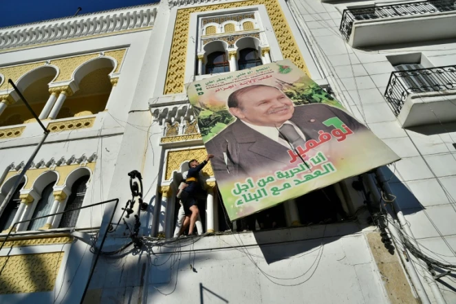 Des manifestants décrochent un portrait géant du président Bouteflika, le 22 février 2019 à Alger