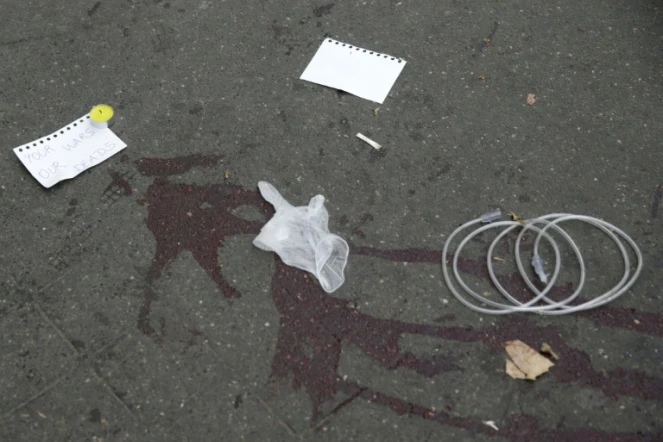 "Vos guerres, nos morts" écrit sur des morceaux de papiers sur le pavé ensanglanté le 14 novembre 2015 près du Bataclan à Paris