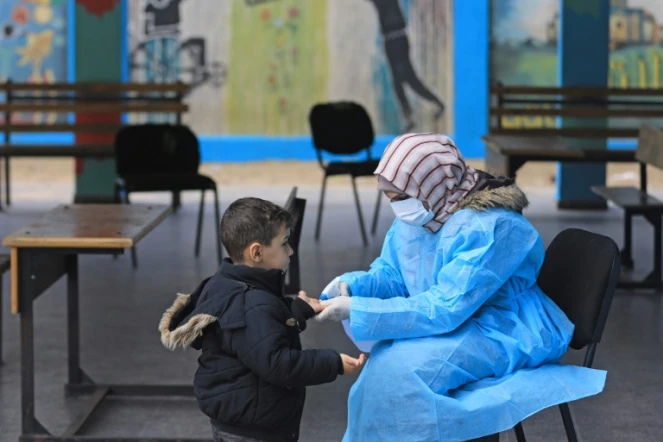 Une Palestinienne prend la température d'un enfant dans une école à Gaza, le 18 mars 2020