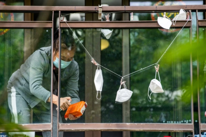 Un résident confiné désinfecte un sac de courses dans le district de Pudong à Shanghai le 1er mai 2022