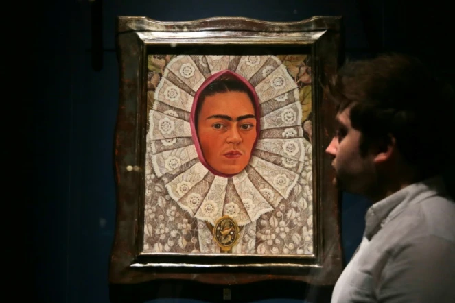 Un employé du musée Victoria & Albert Museum de Londres devant un autoportrait de Frida Kahlo lors d'une exposition consacrée à l'artiste mexicaine, le 13 juin 2018