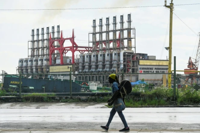 Un Cubain marche à côté d'une centrale électrique flottante dans le port de La Havane, le 21 octobre 2024
