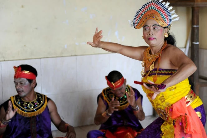 Des Balinaises en corsage doré dansent sur une musique traditionnelle devant des hommes assis par terre jambes croisées autour d'elles en remuant leurs mains. Un show dont tous les acteurs sont sourds
