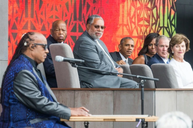 Stevie Wonder chante en présence de Barack Obama (au c.) et de son prédécesseur Georges W. Bush (2e à d.) lors de l'inauguration du Musée dédié à la culture afro-américaine, le 24 septembre 2016 à Washington