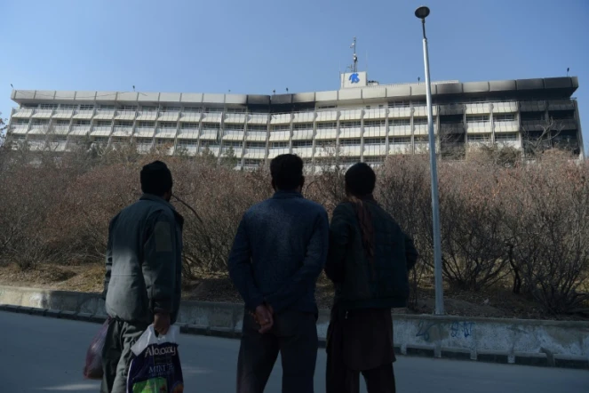 Des Afghans regardent l'hôtel Intercontinental à Kaboul le 22 janvier 2018 après une attaque menée par des talibans dans l'établissement qui a fait au moins 22 morts