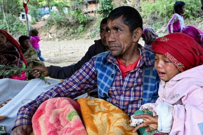 Des proches de victimes d'un violent séisme pleurent, à côté de leurs corps, dans le village de Chiuri, dans l'ouest du Népal, le 5 novembre 2023 
