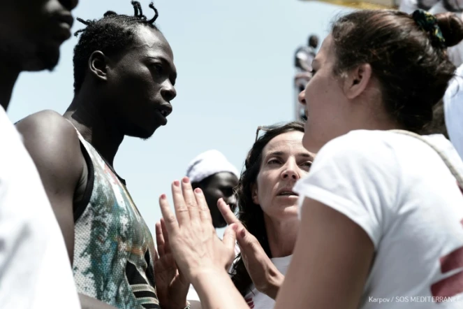 Une photo prise le 11 juin et distribuée par SOS Méditerranée montre des membres de l'ONG en train de parler aux migrants à bord de l' Aquarius
