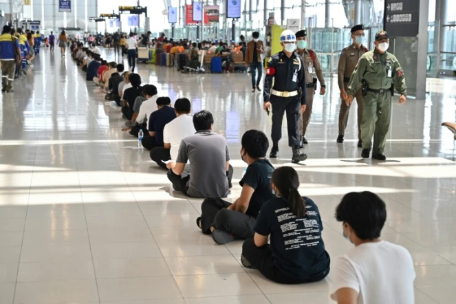 Des personnels de l'aéroport font la queue avant d'être vaccinés contre le covid-19 au terminal départ de l'aéroport Suvarnabhumi à Bangkok le 30 juin 2021
