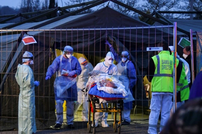 Des équipes médicales transfèrent des patients contaminés par le coronavirus d'un hôpital militaire pour les évacuer dans un TGV médicalisé vers des hôpitaux de la Nouvelle-Aquitaine, le 29 mars 2020 à Mulhouse