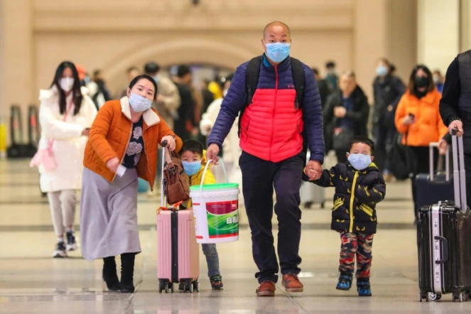 Des voyageurs portant un masque sur la bouche à la gare de Hankou à Wuhan (Chine), le 21 janvier 2020