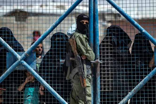 Un combattant des forces kurdes en faction devant une porte du camp d'Al-Hol, dans le nord-est de la Syrie, le 15 juillet 2021