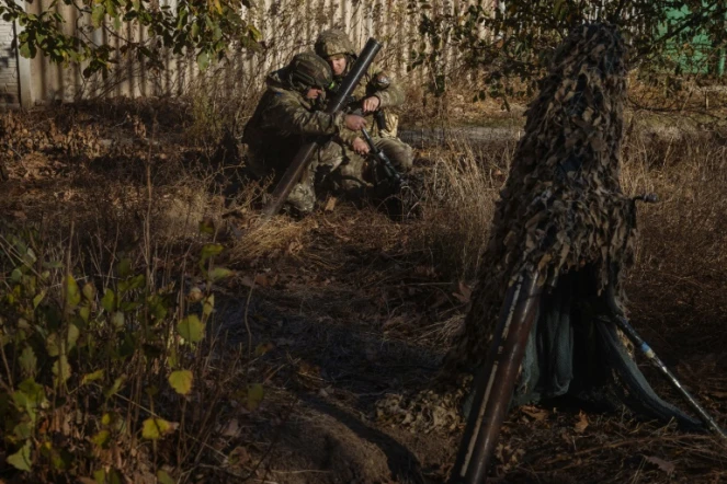 Des soldats de la 123ème brigade de défense territoriale ukrainienne se préparent à tirer au mortier vers des positions russes situées de l'autre côté du Dniepr, depuis une emplacement non identifié dans la région de Kherson, le 6 novembre 2023